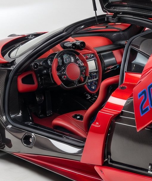 Red leather cabin and carbon steering wheel seen through the open door